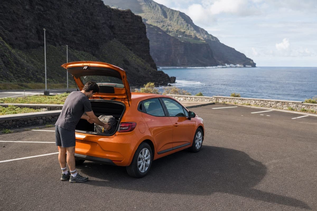 Traveller loading a compact rental car beside El Hierro's volcanic coast